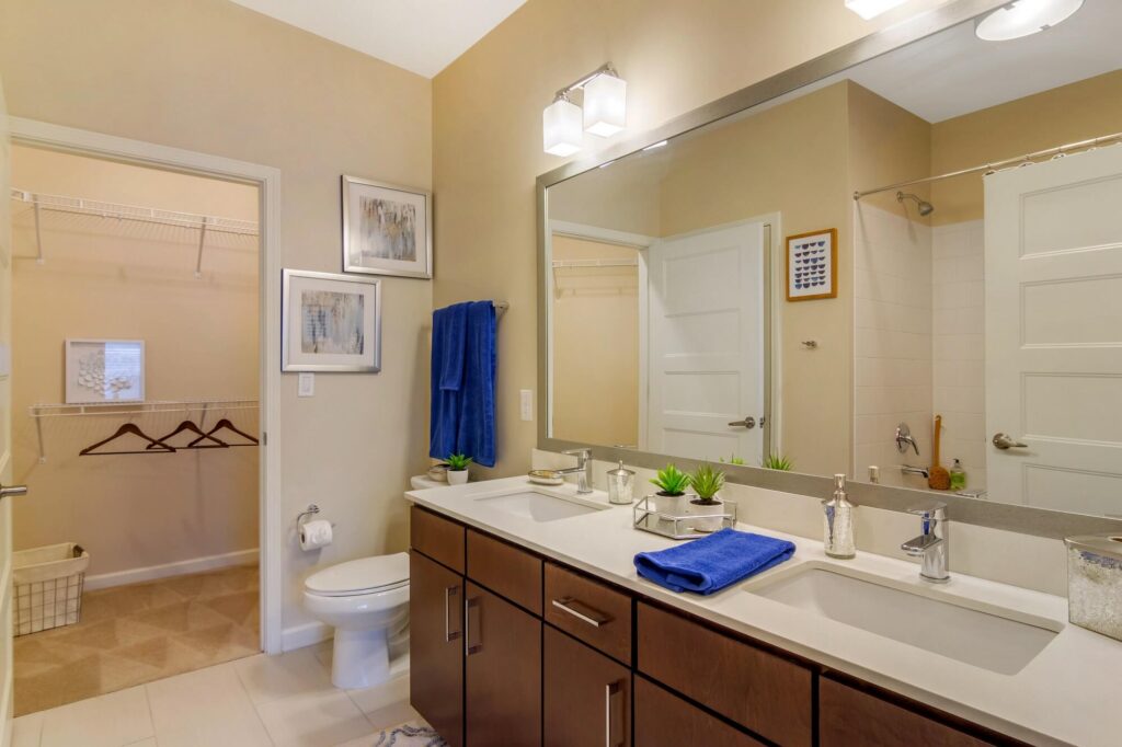 Bathroom with walk in closet, 2 sinks, large window and marble counter tops