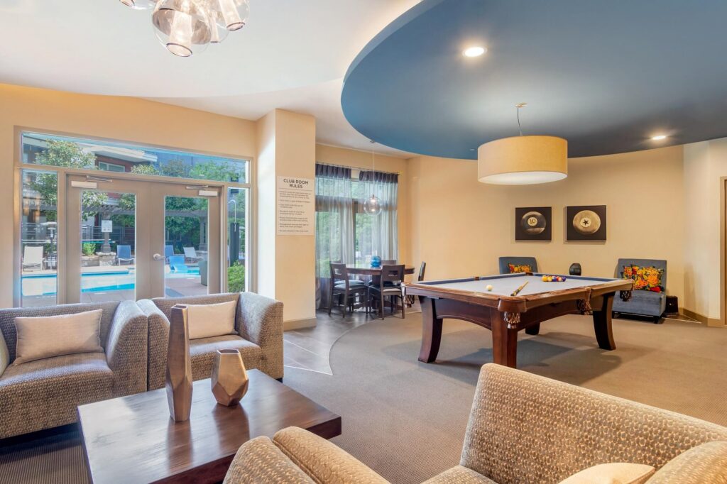 Club house interior with pool table and chairs. Club room rules posted on the wall