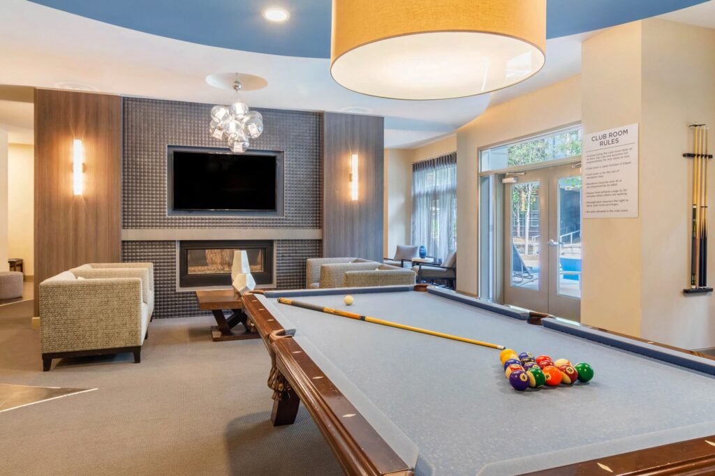 clubhouse interior with pool table, fireplace and tv. Club room rules posted on the wall