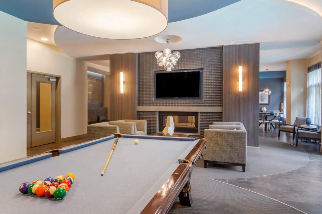 clubhouse interior with pool table, fireplace and tv.